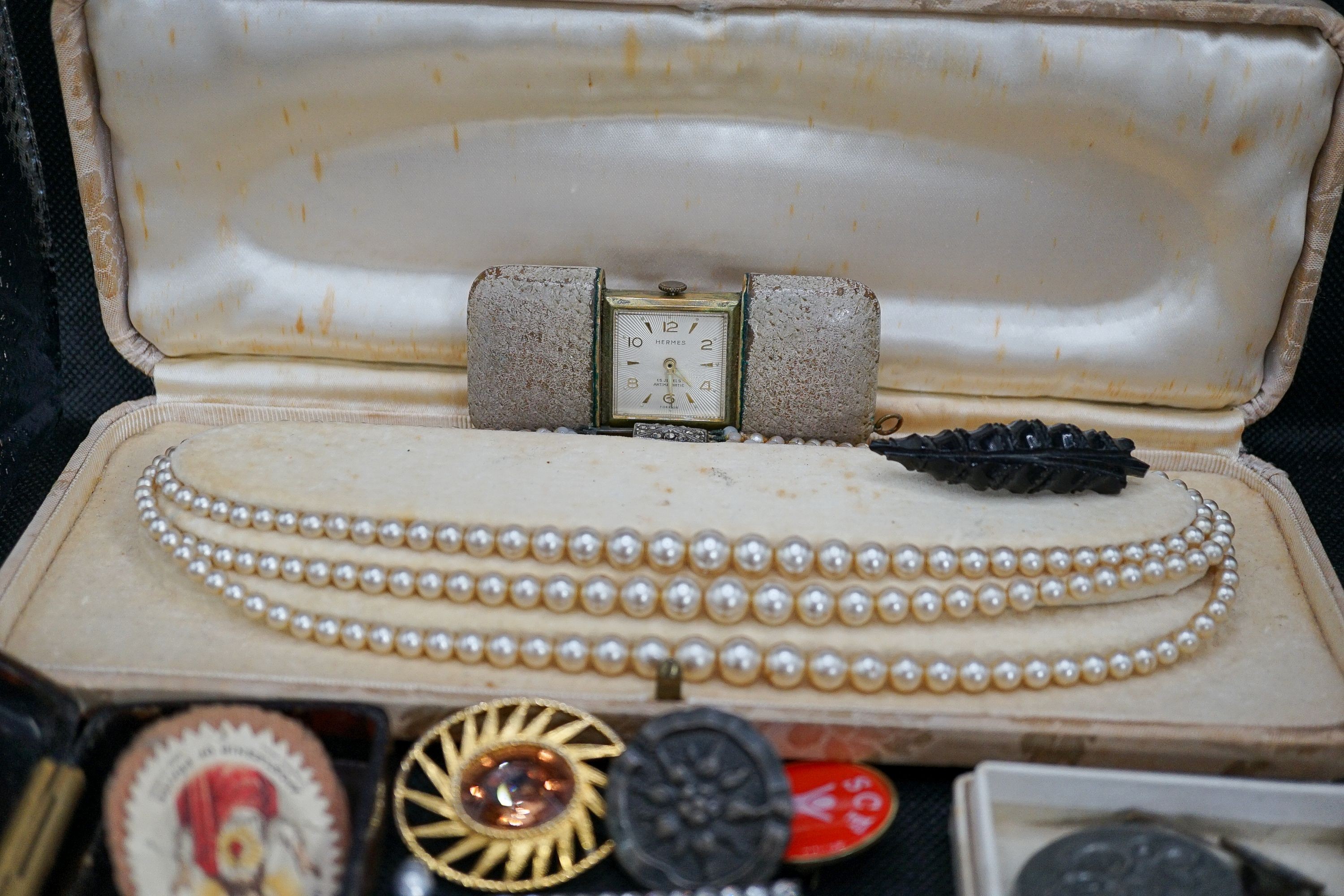 A group of costume jewellery to include a Hermes travelling timepiece.